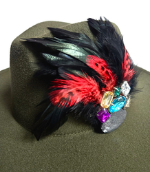 Elegant women's hat with large brooch with feathers and colored zircons